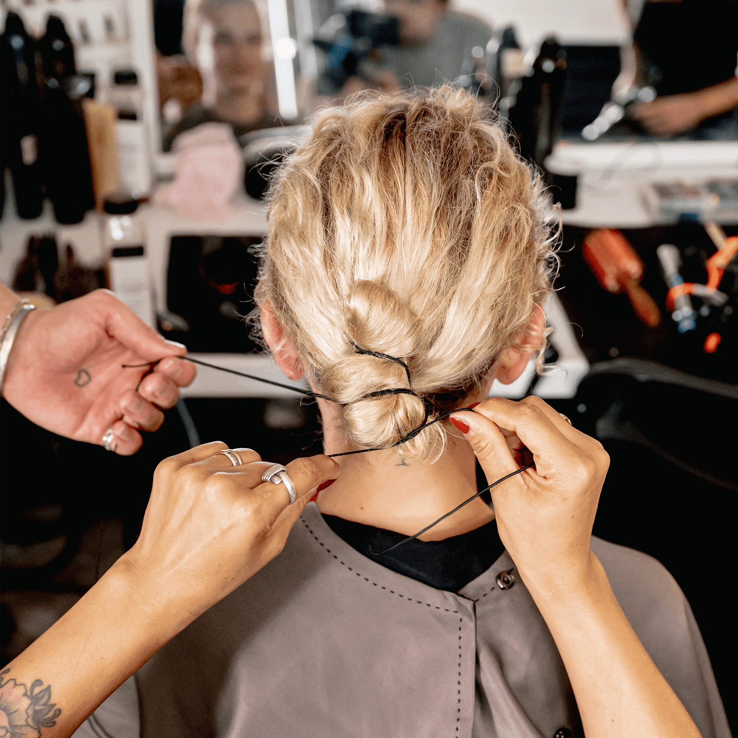 Model with curly hair tied back into a bun