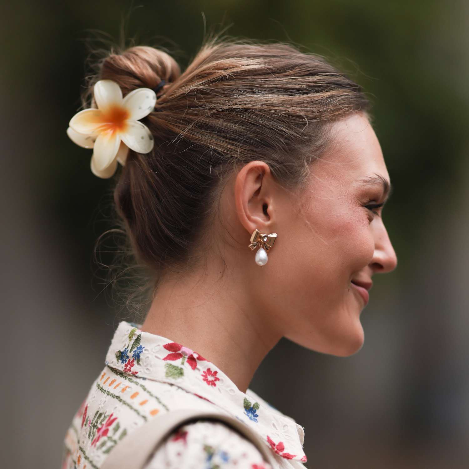 Copenhagen fashion week guest wears her hair in a bun with a flower shaped claw clip