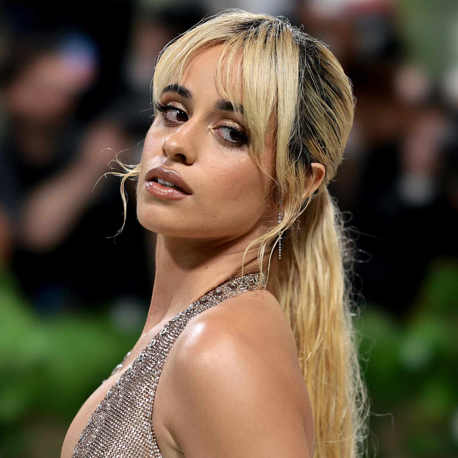 Camila Cabello attends The 2024 Met Gala with a long curtain fringe and a long, low ponytail