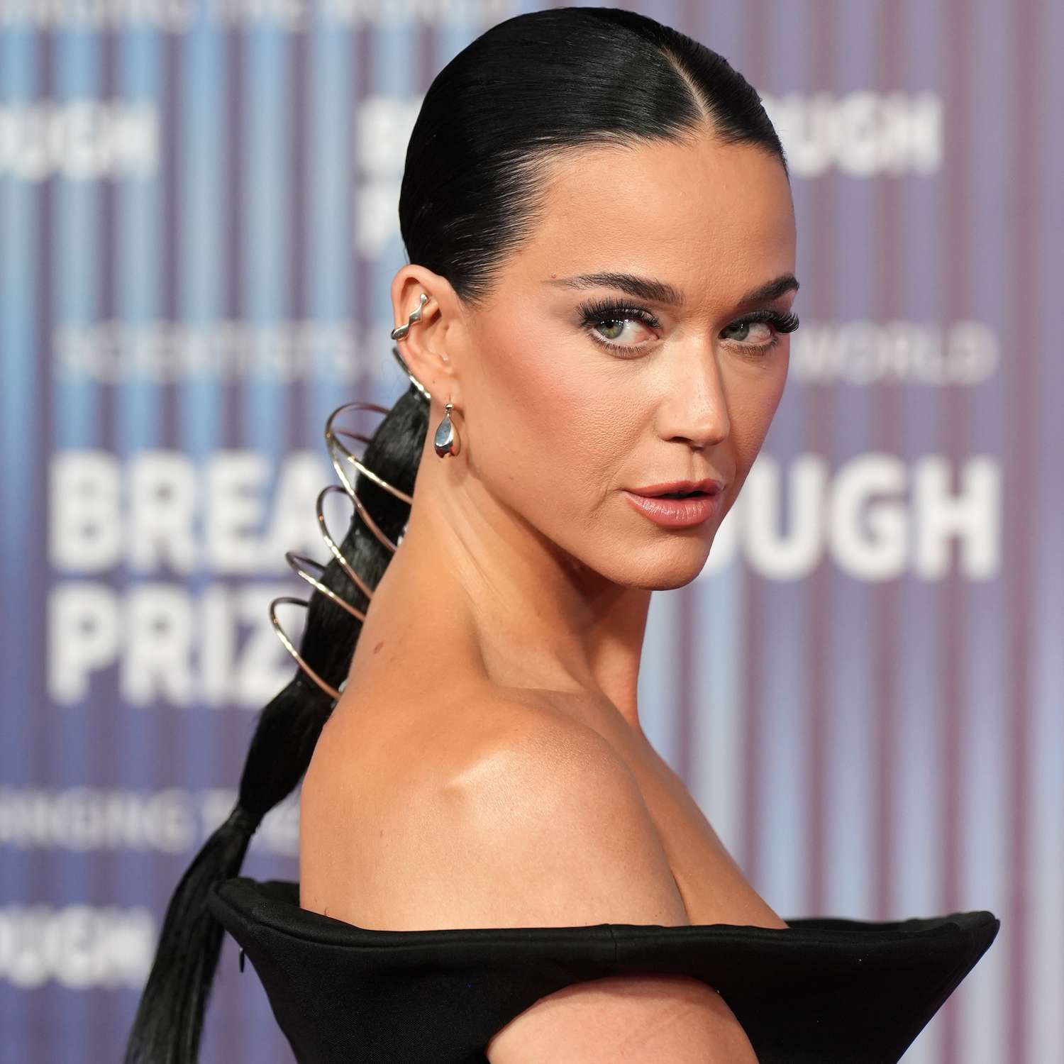 Katy Perry wears a low, sleek bubble ponytail adorned in a silver coiled accessory