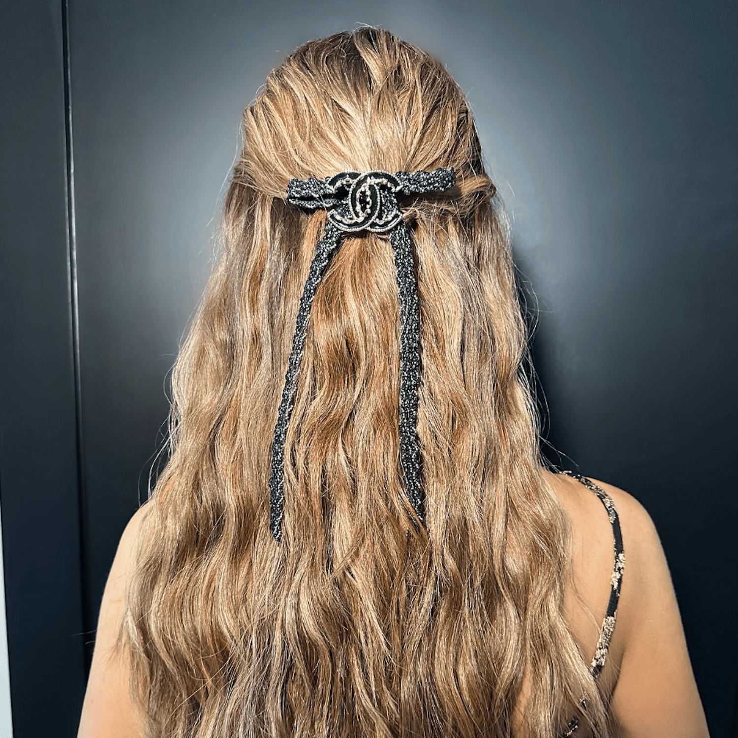 Dorit Kemsley wears long beachy waves in a half-up half-down style with a Chanel broche in the center