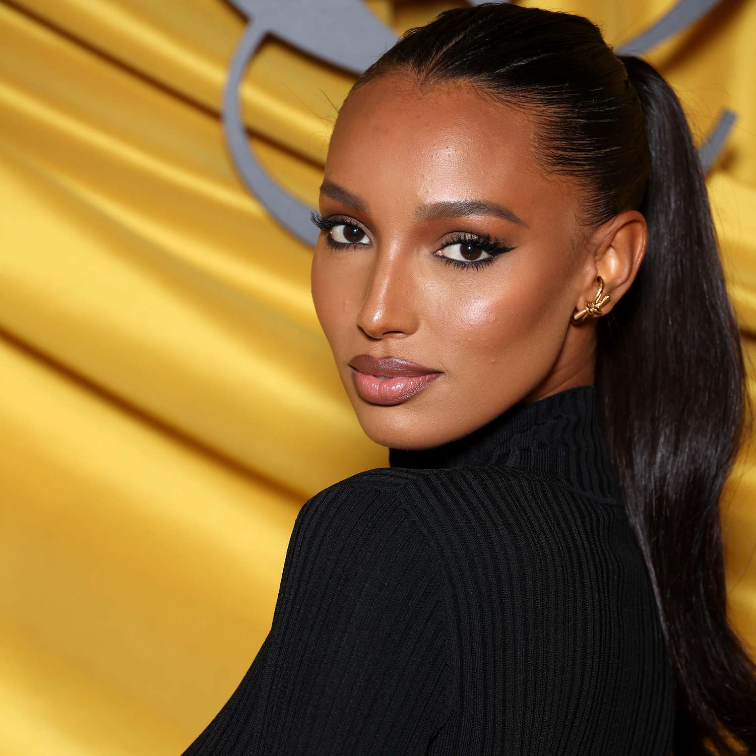 jasmine tookes with dark hair pulled back into slick ponytail