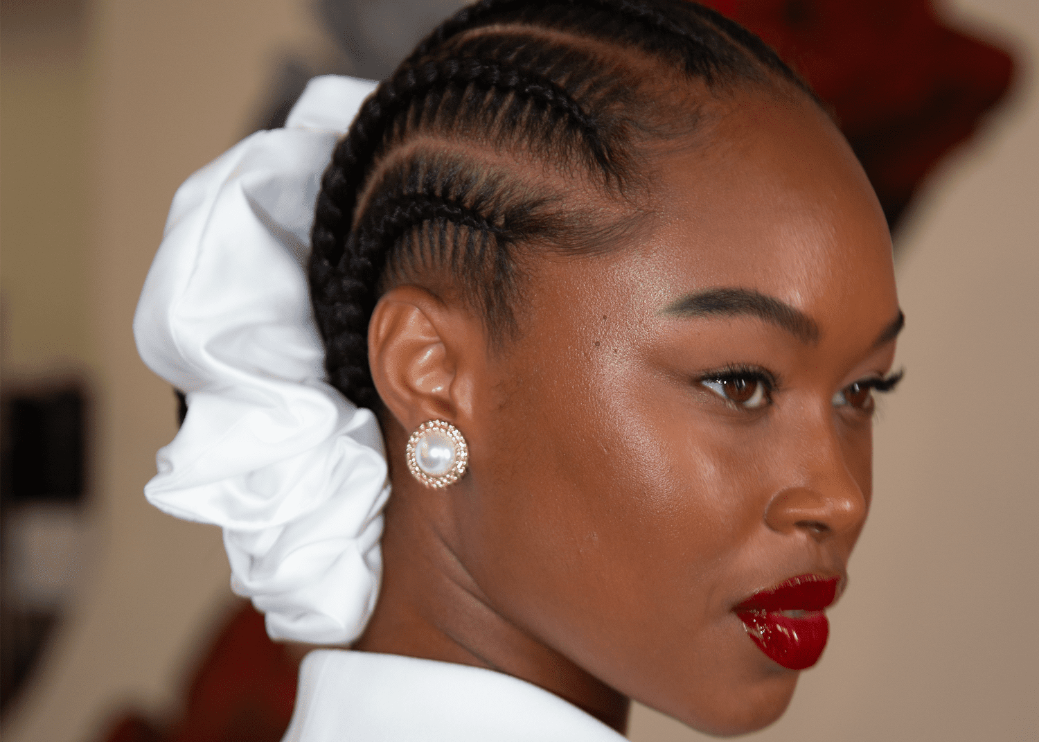 Model with braids going into a low bun and a large satin scrunchie